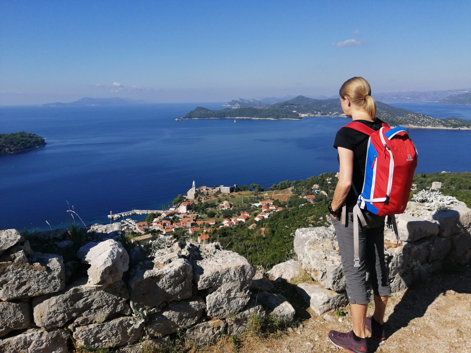 Nainen katselee merelle ylhäällä näköalapaikalla.