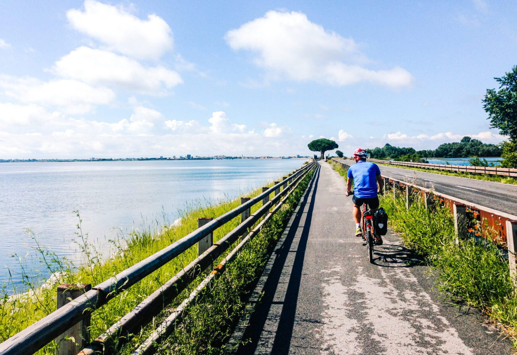 Mies pyöräilee Adrianmeren rannikon pyörätiellä aivan meren äärellä.