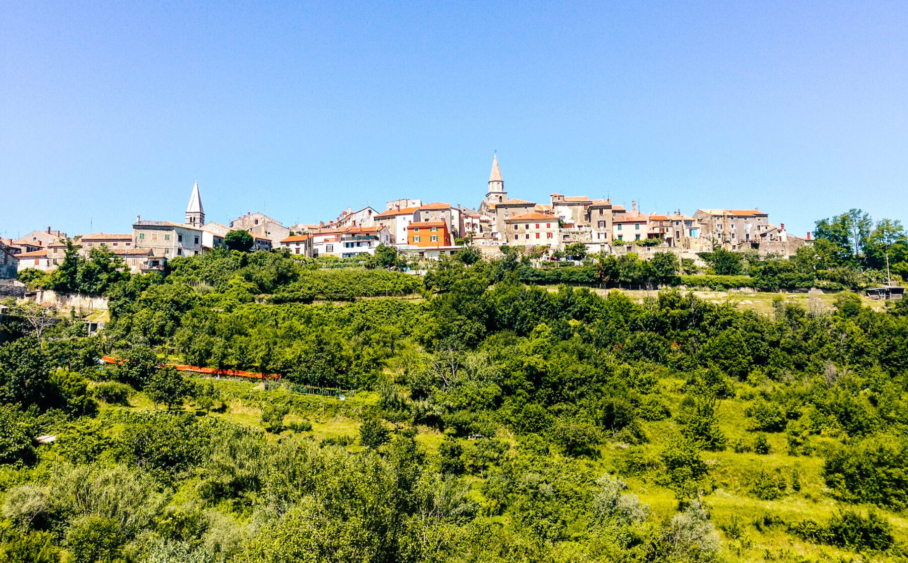 Pieni tiiviisti rakennettu kylä kukkulan laella.