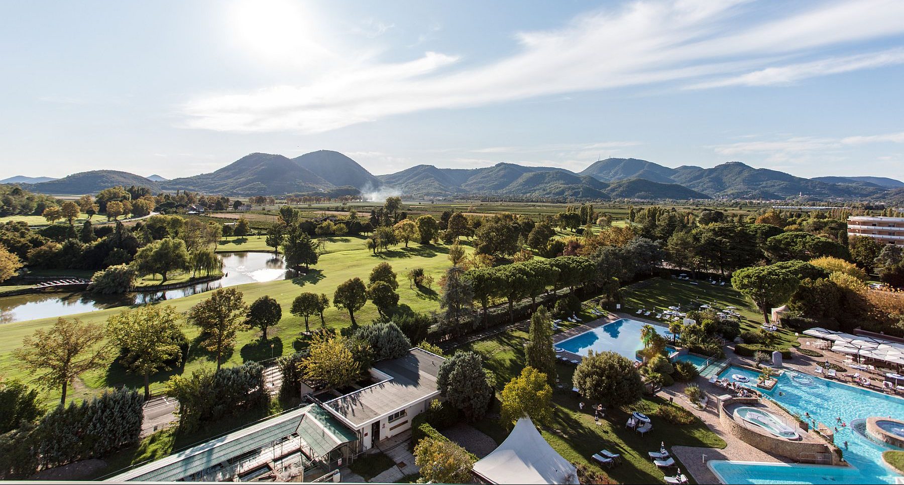 Vehreän puistoalueen ympäröimä kylpyläkompleksi altaineen.