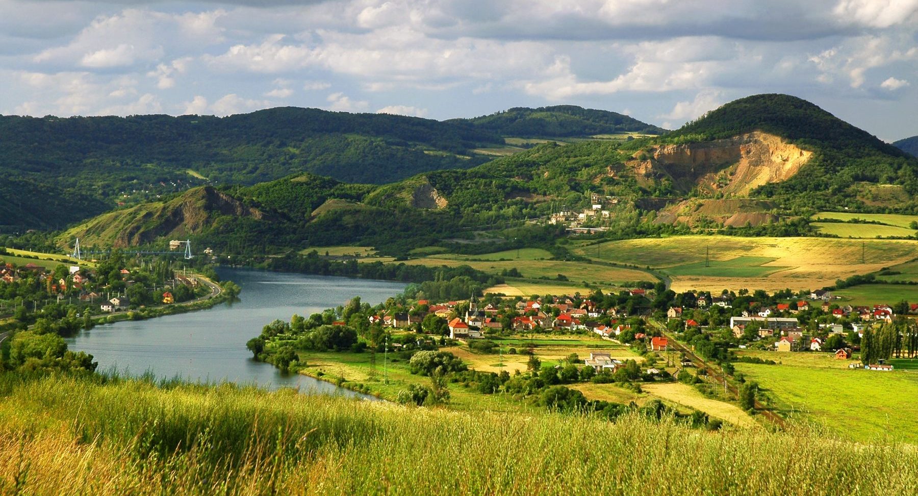 Joki, jota ympäröivät vehreät kukkulat