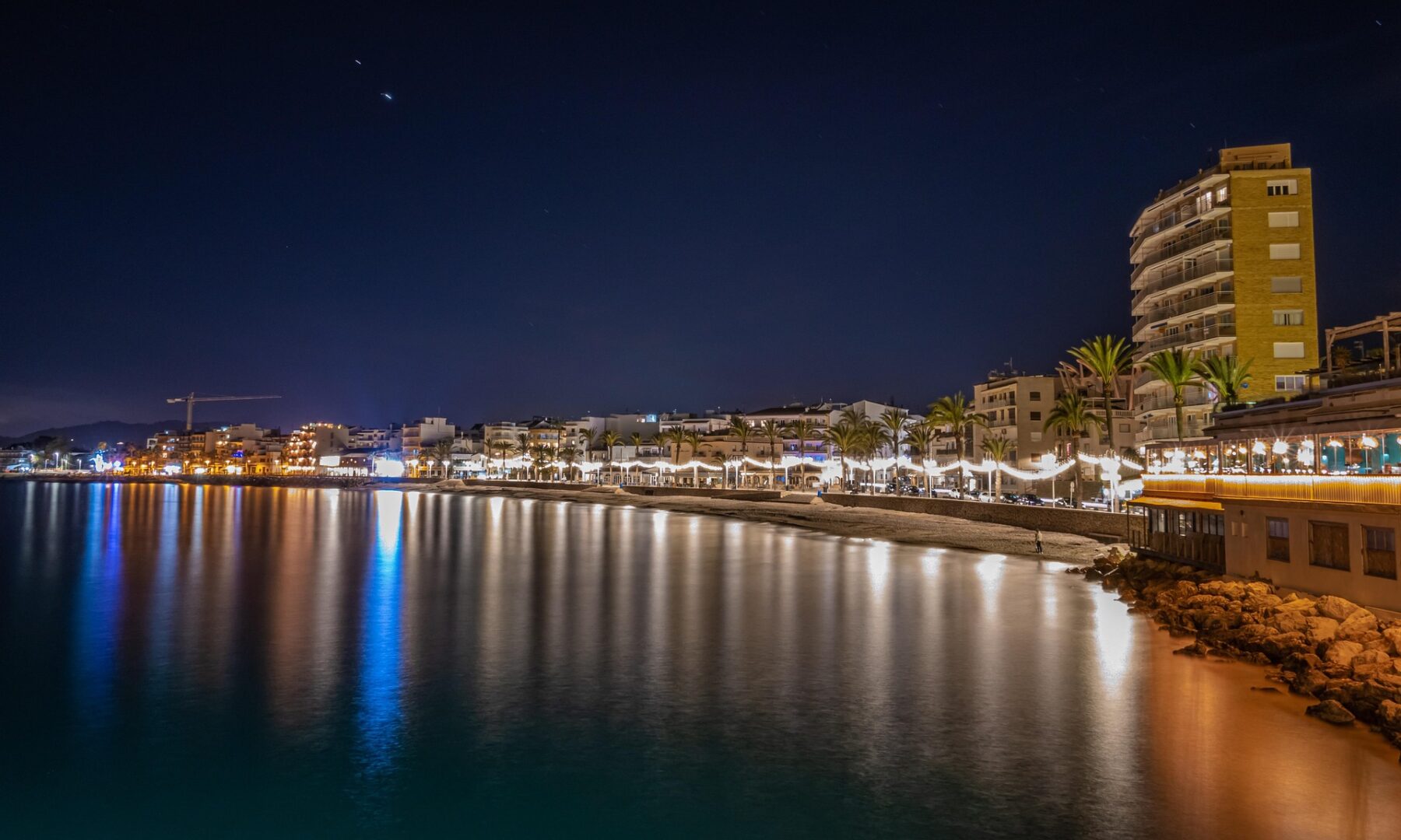 Rantakatu ja kaupunkia iltavalaistuksessa mereltä katsottuna.