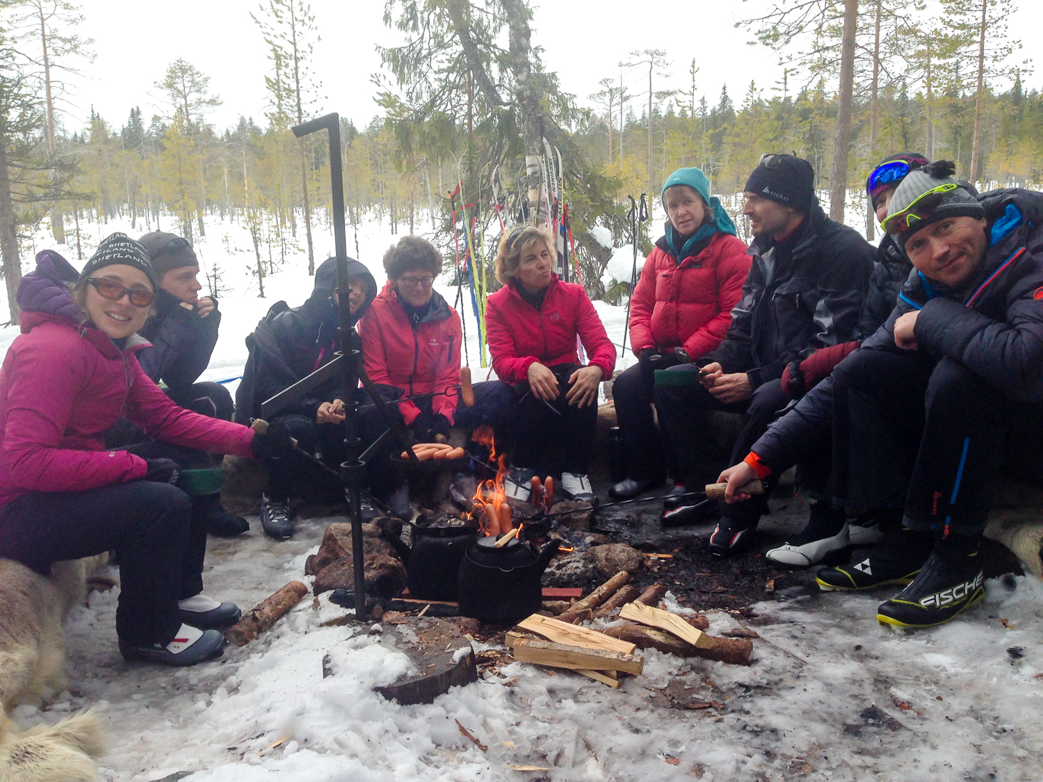 Hiihtoryhmä lounastauolla nuotion ympärillä